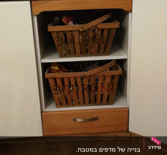 שתי סלסלות עץ בתוך ארון מטבח פתוח